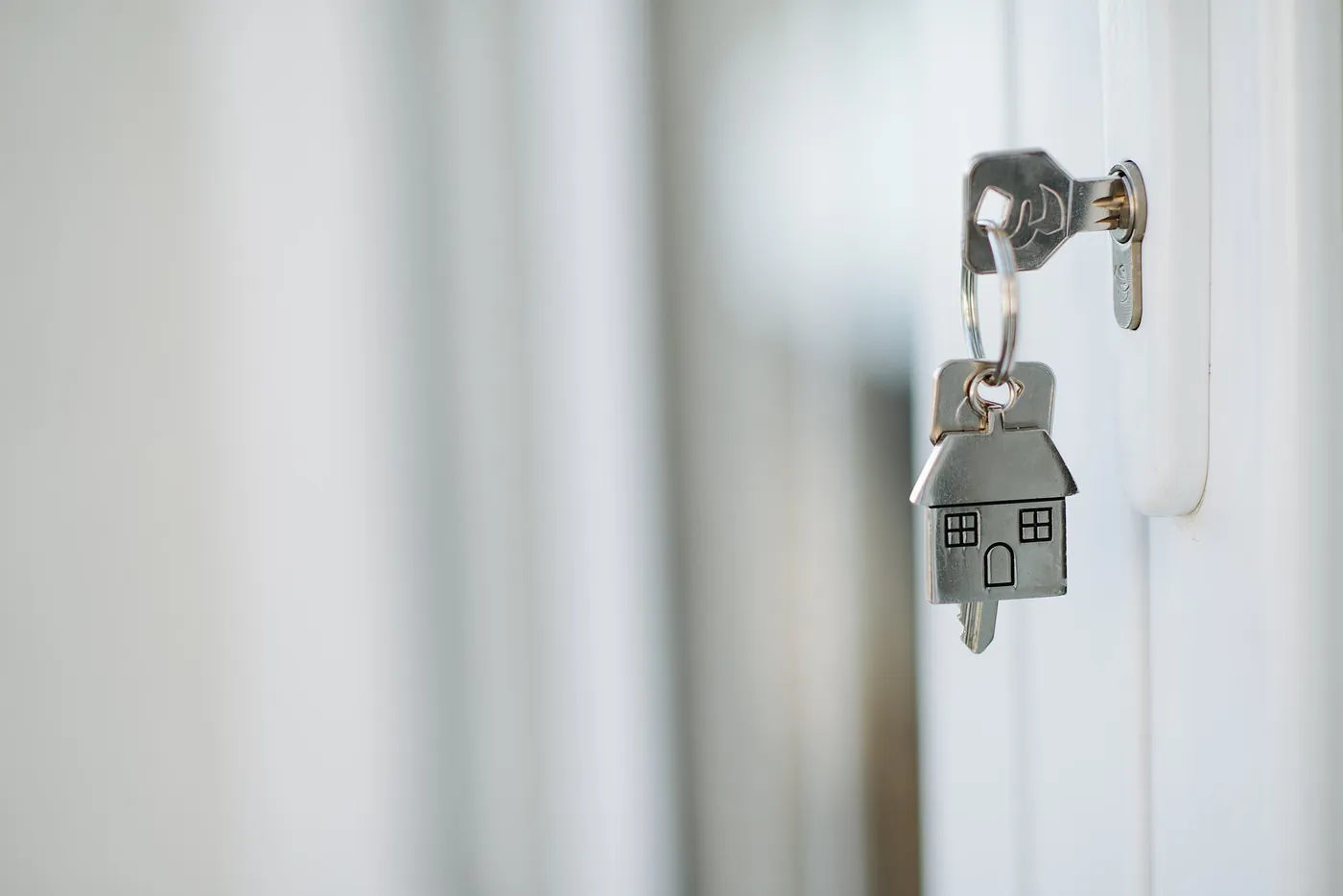 Key and house-shaped key ring in a door lock